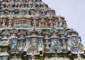 KUMBAKONAM, INDIA - OCTOBER 12, 2013: Mahalingeswarar Temple. Statue composition on Gopuram. Multitude of statues in pastel colors. About seven layers can be seen.